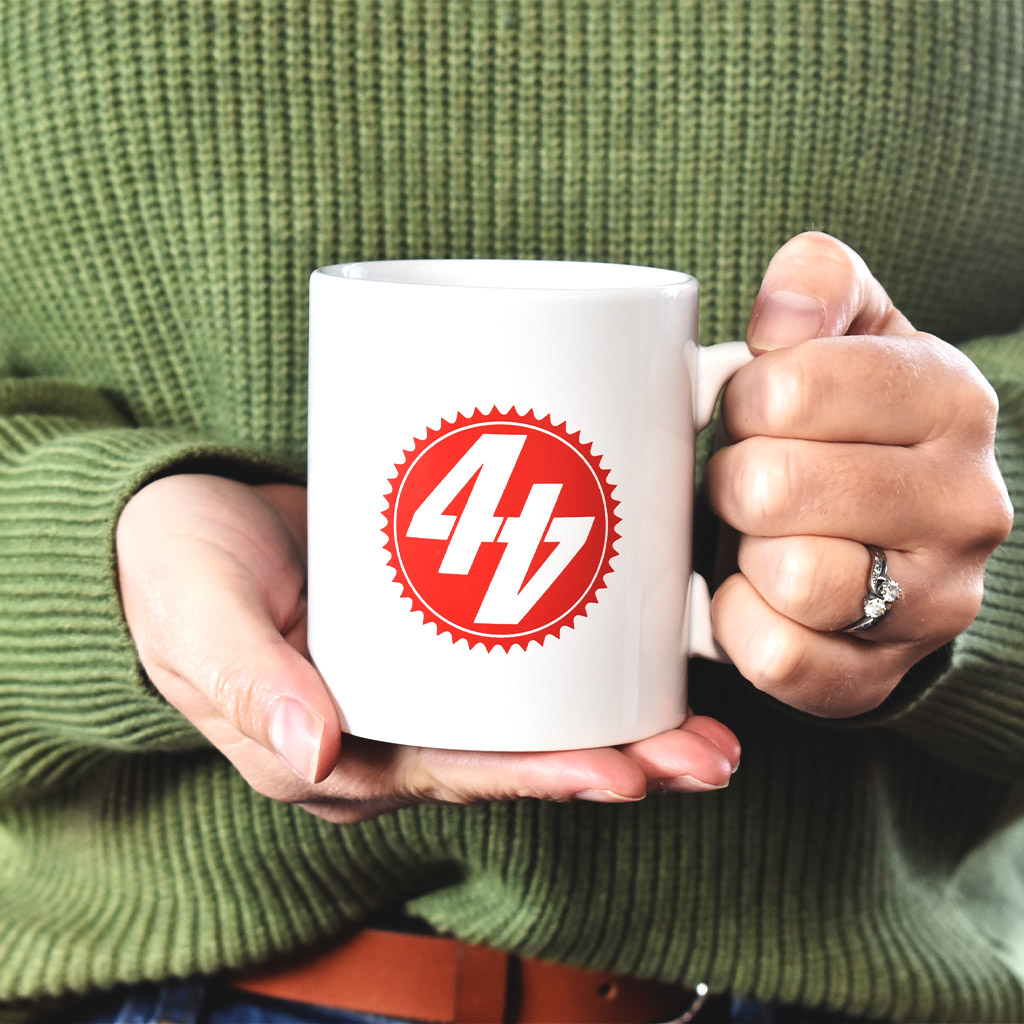 White mug with red 44Teeth logo print on it and hands holding it